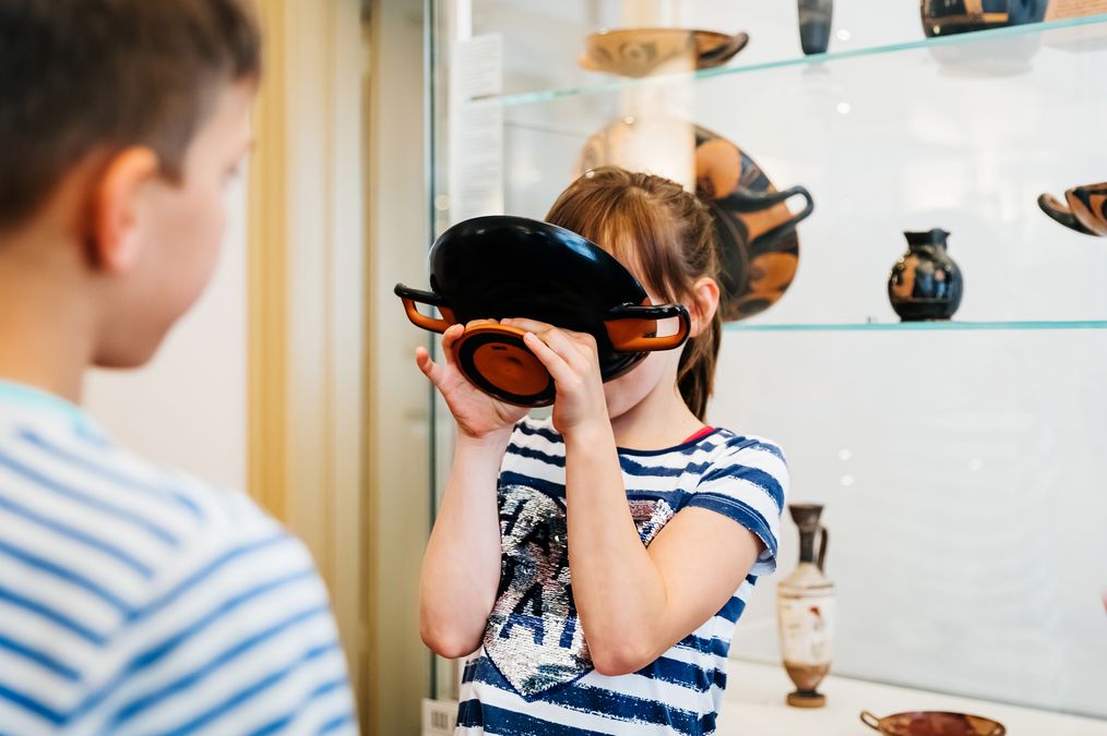 zur Vergrößerungsansicht des Bildes: Schüler probieren anhand einer Replik den Umgang mit antiken Trinkgefäßen aus.
